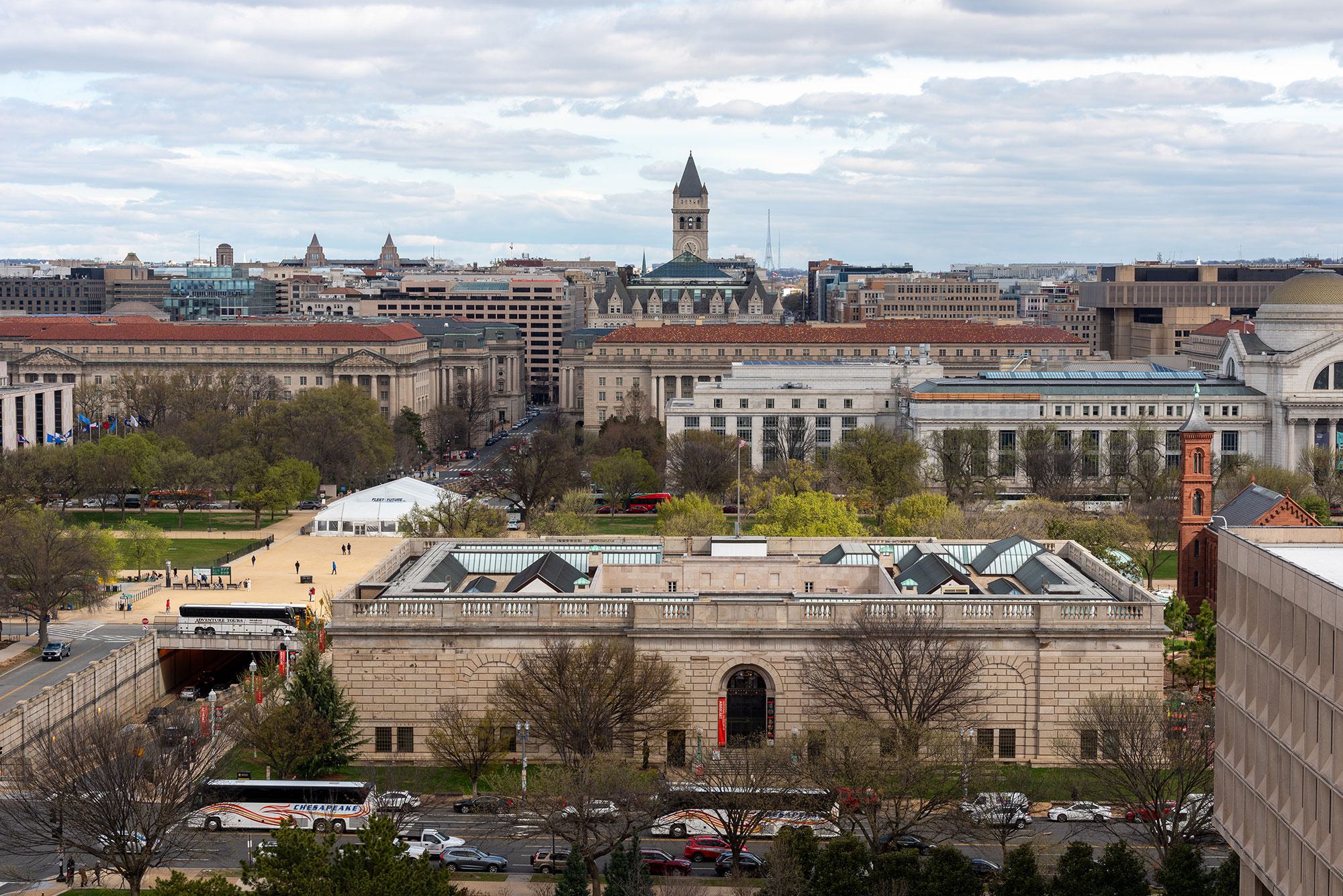 View from Southwest DC toward the National Mall, showing Smithsonian museums, federal buildings, and long monument sightlines under a cloudy sky.