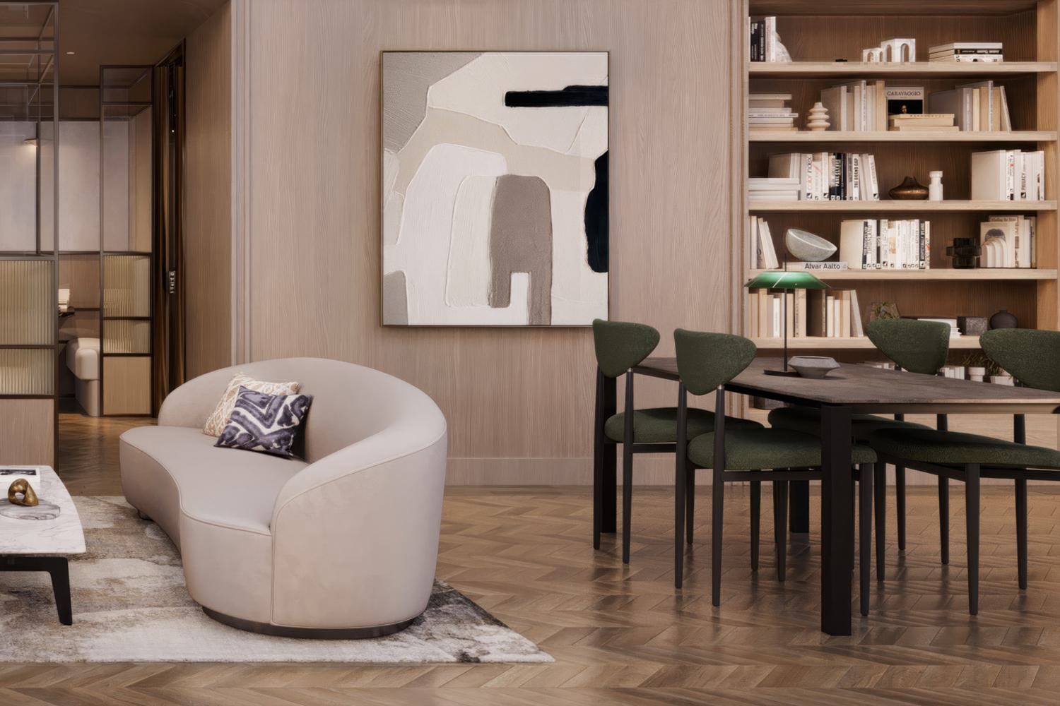 Coworking lounge with oak-paneled walls, built-in wood bookshelves, herringbone wood floors, abstract artwork, a curved upholstered lounge chair, marble coffee table, and a communal work table with green upholstered chairs and a desk lamp.