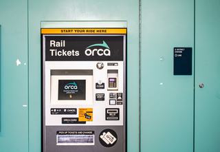 Light rail ticket machine and ORCA card reader used for transit at a Seattle Link station, representing travel from Columbia City via light rail.