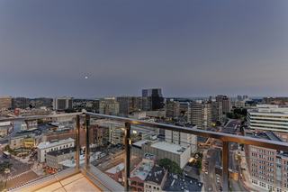 View from a Vela on the Park high-rise balcony at dusk, featuring glass railings, a bird's-eye view of downtown Stamford streets, and the moon over the horizon.