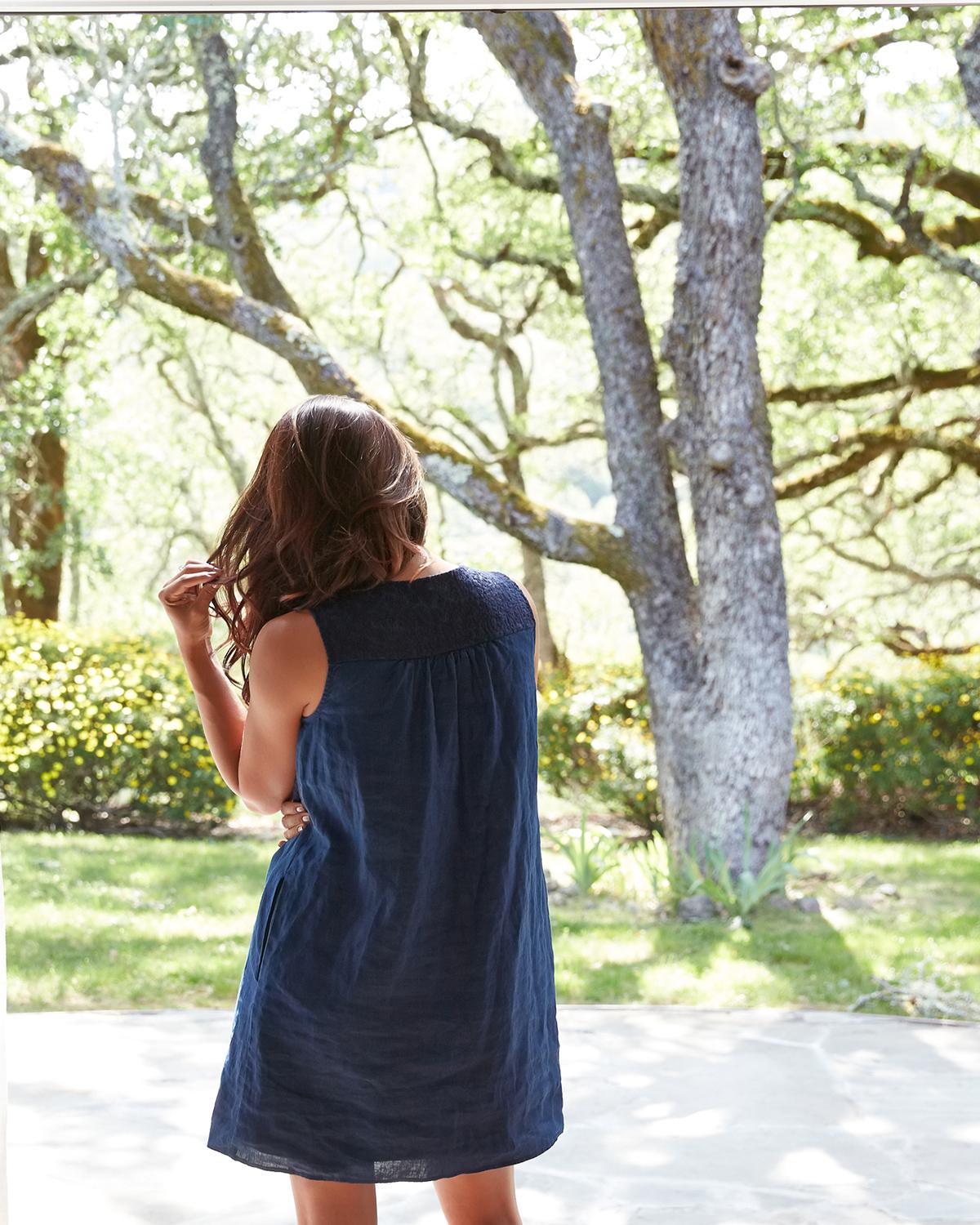 Woman standing in a doorway looking out to beautiful trees
