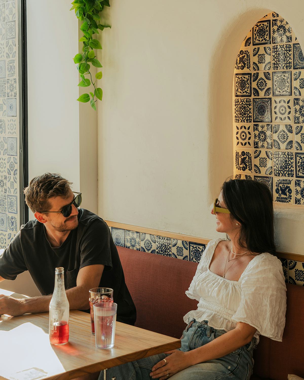 Man and woman smiling inside a local restaurant