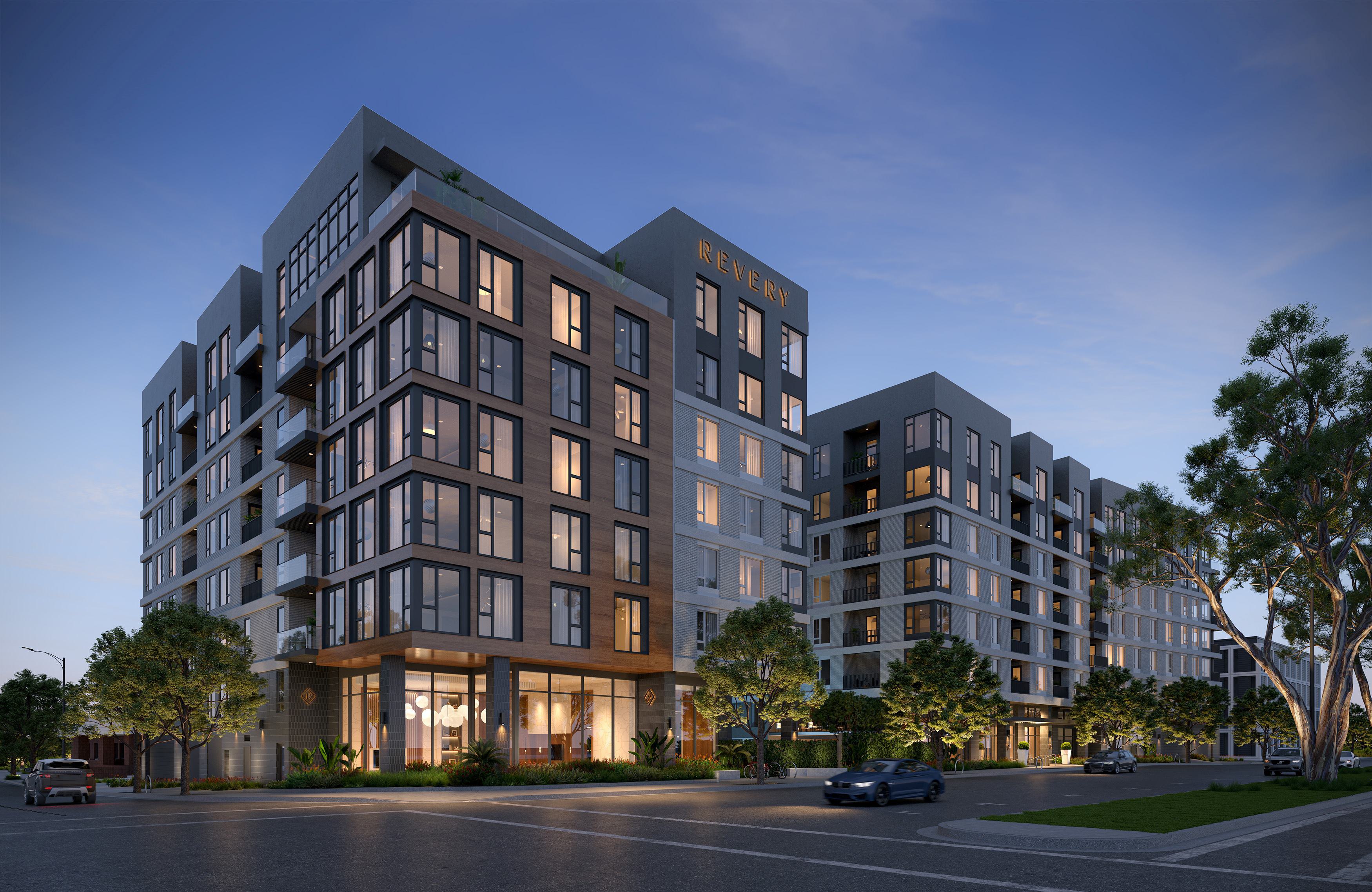A high-angle exterior rendering of Revery, a modern multi-story apartment building at dusk. The architecture features a mix of dark grey masonry, warm wood-paneled accents, and large floor-to-ceiling windows. The street level shows a glowing glass-walled lobby, manicured sidewalk greenery, and a few luxury cars passing by under a clear twilight sky.