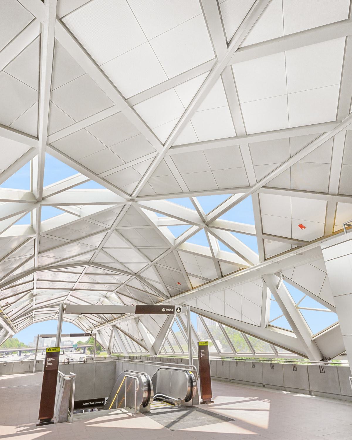 Modern, geometric canopy ceiling above the platform stairs and escalators at the Reston Town Center Metro station.