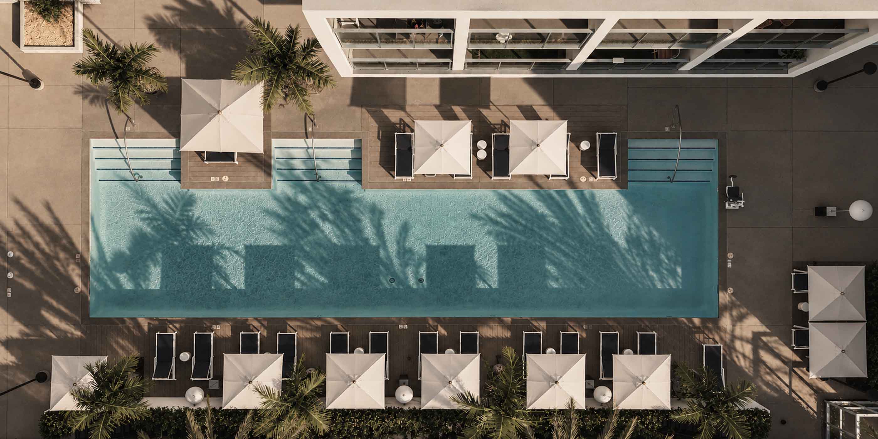 Aerial shot of Stella pool area showing seating, the building and trees around.