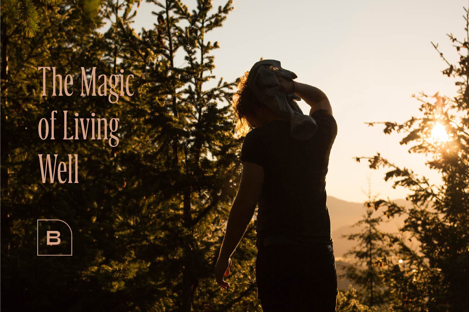 A silhouette of a person surrounded by lush trees with the text "The Magic of Living Well," emphasizing the proximity to nature and parks near The Bowden in Redmond.