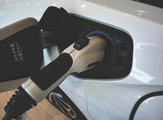 close up of a white ev car being charged