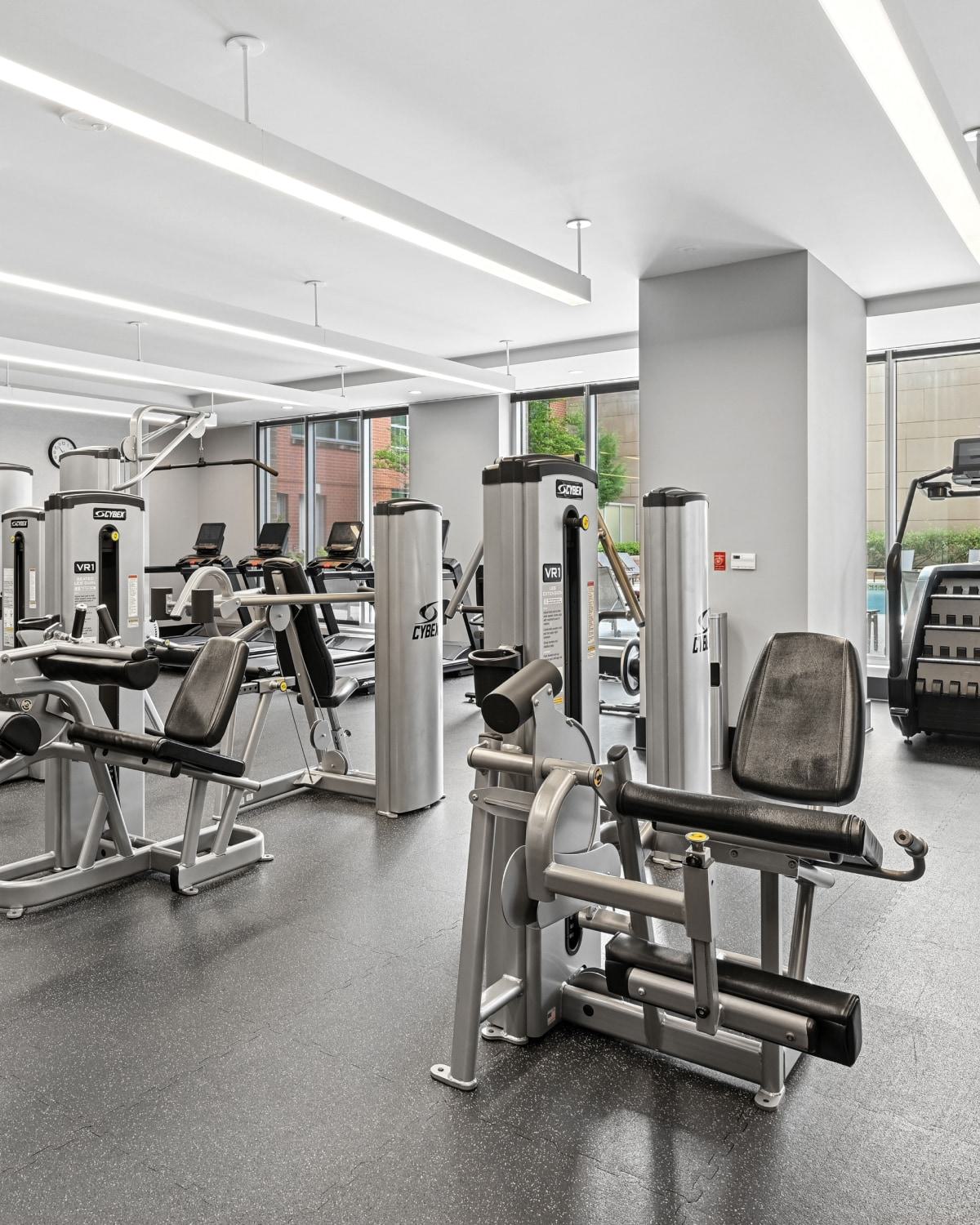 Spacious fitness center at Avant Reston equipped with weight machines, cardio equipment, and large windows.