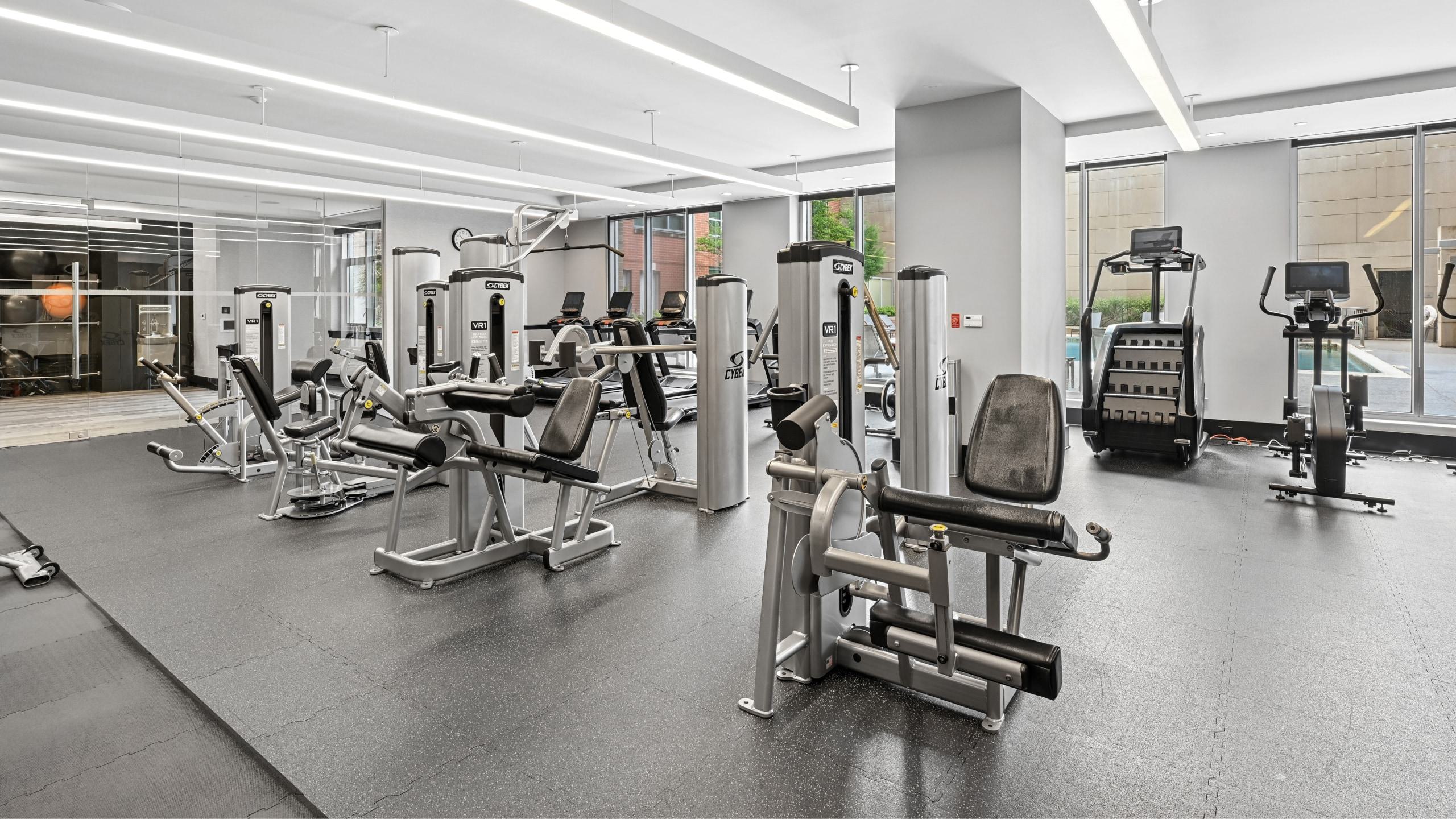 Spacious fitness center at Avant Reston equipped with weight machines, cardio equipment, and large windows.