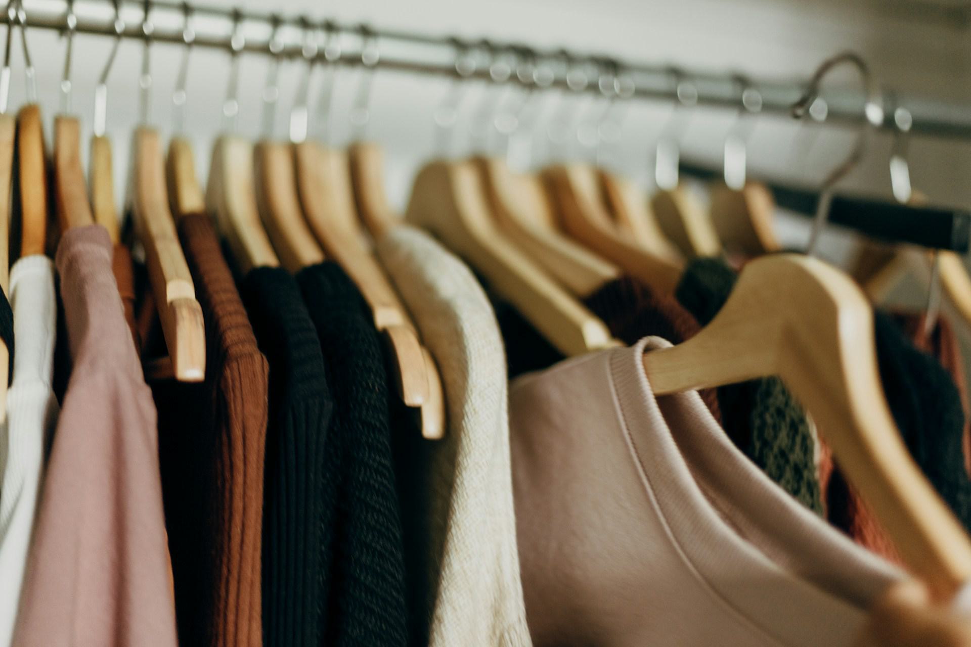 close-up image of an organized closet with clothing on hangers