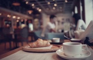 A croissant and latte on a cafe table