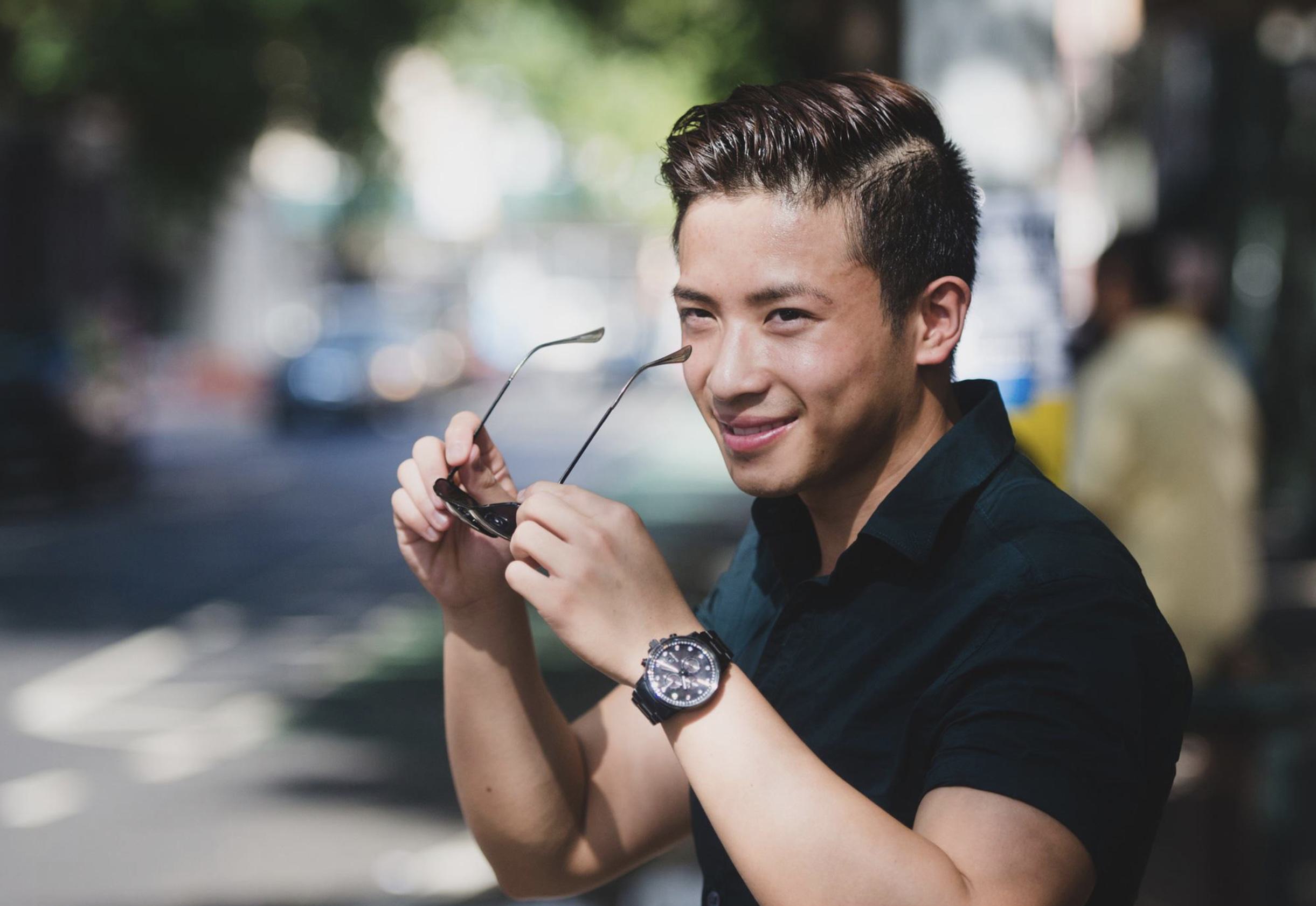 a smiling man putting on sunglasses, walking around Hillcrest / University Ave are