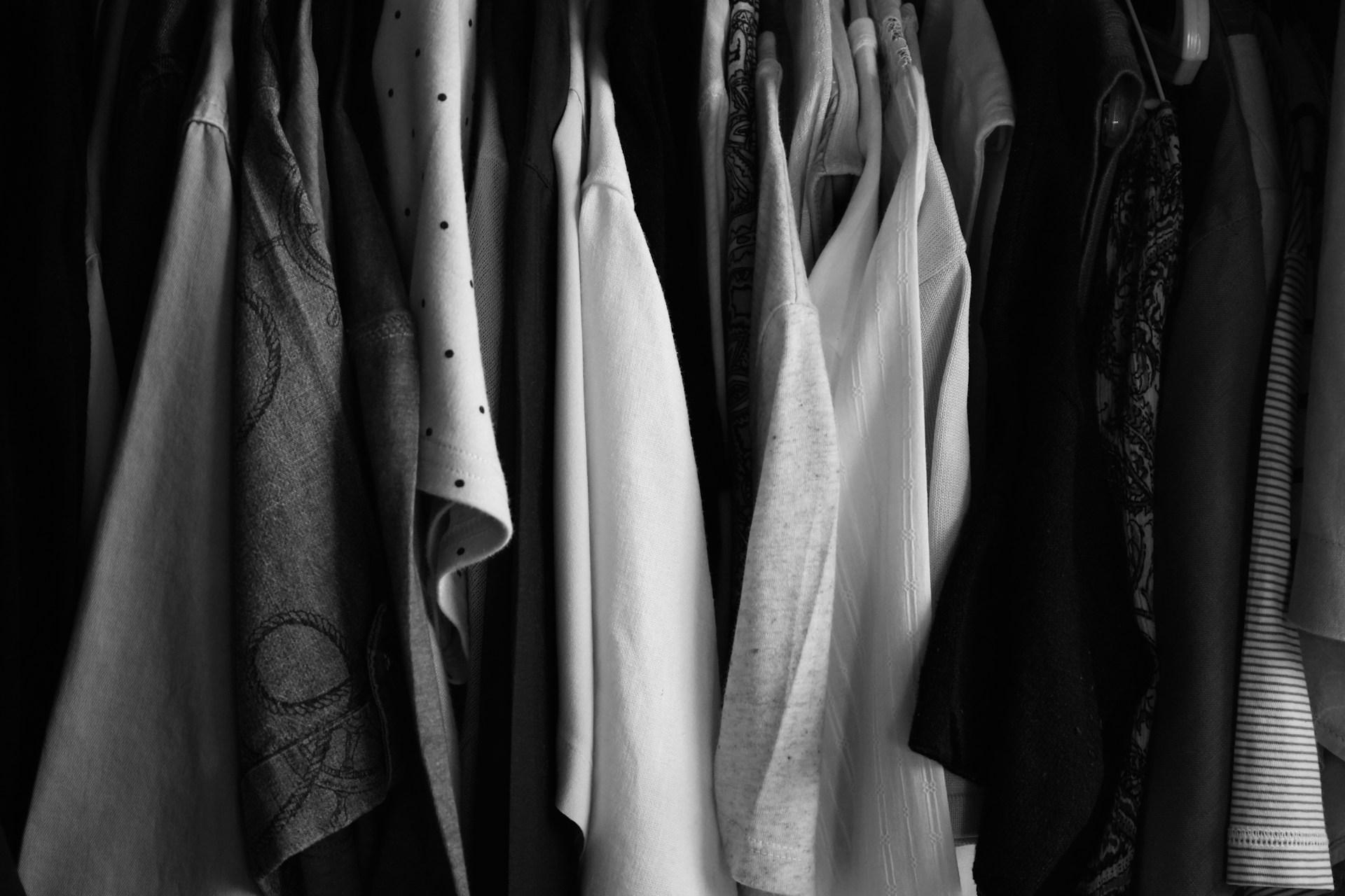 black and white close up image of clothes hanging in a closet