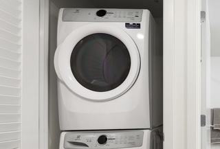 A stacked white Electrolux washer and dryer set installed inside a closet at The Victor apartments in Seattle.