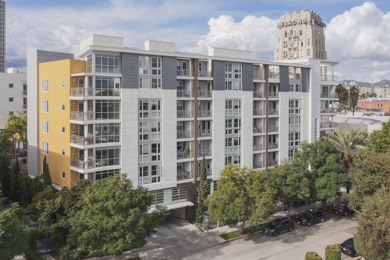 Exterior of The Desmond apartment building with private balconies and the historic Desmond’s Art Deco tower in the background.