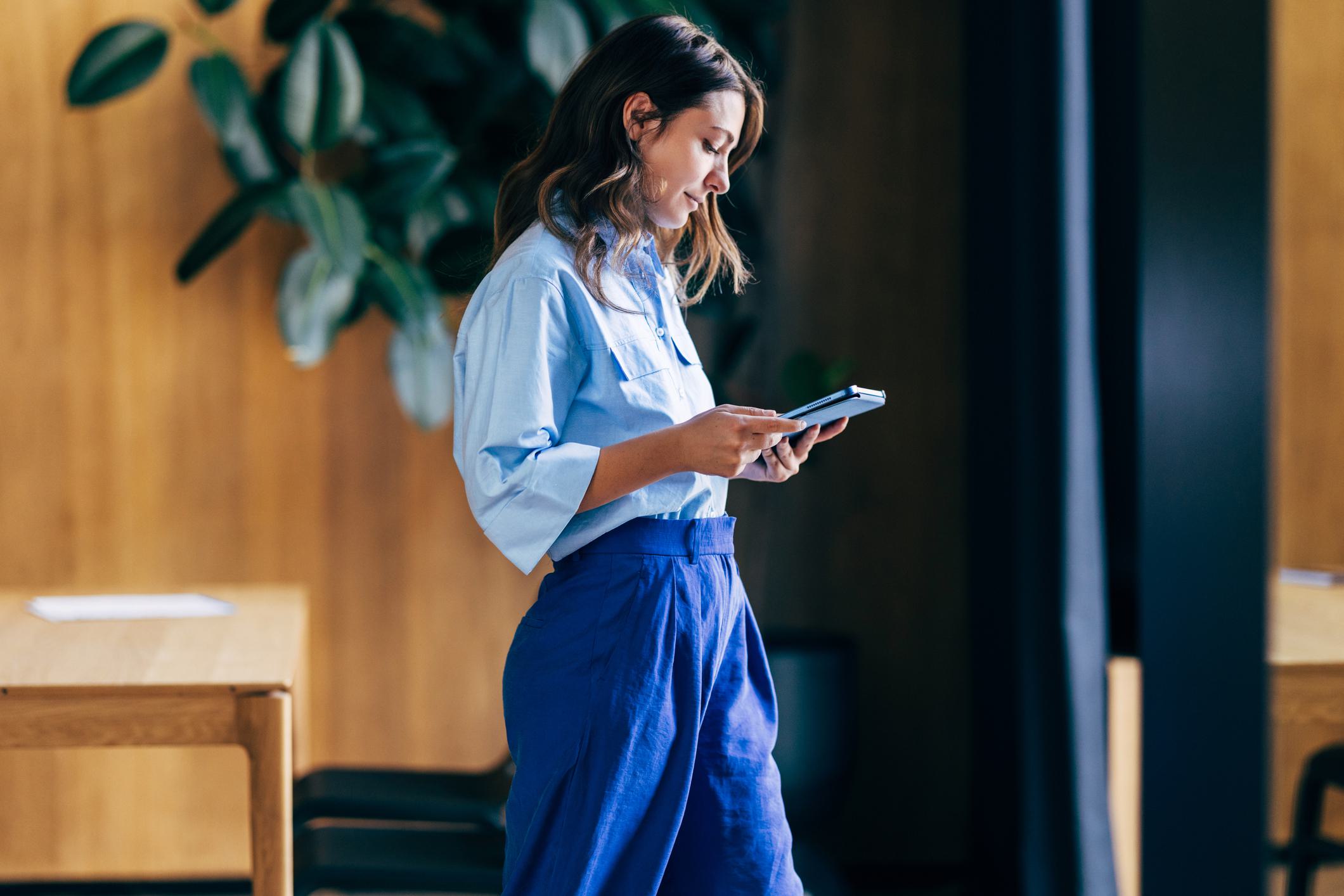 woman walking and holding phone