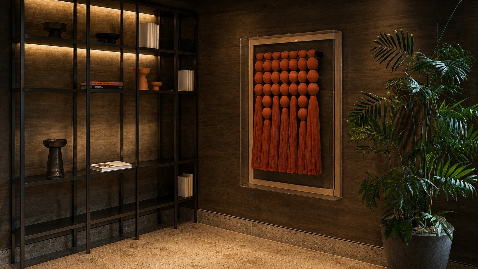 Terracotta fiber wall sculpture with rounded woven forms and long tassels.