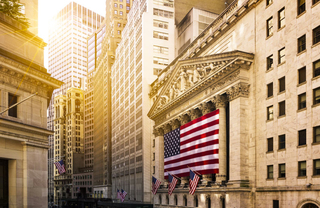 Flag hanging outside of the New York Stock Exchange building at dusk.