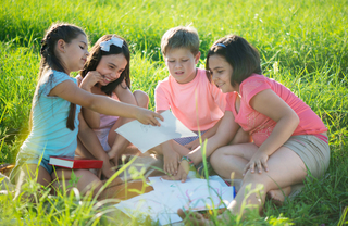 A group of kids sitting in the grass
