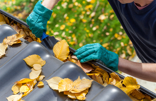 A close-up of a person cleaning roof gutters