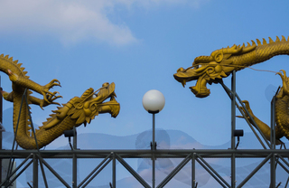 Two dragon statues near a street light