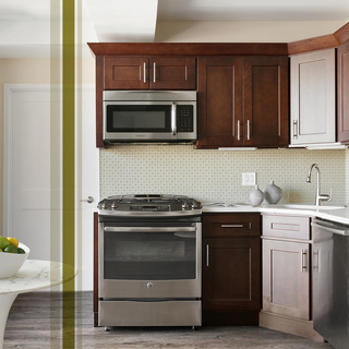 Kitchen with wood cabinets, white quartz counters, stainless steel appliances, and a white tile backsplash