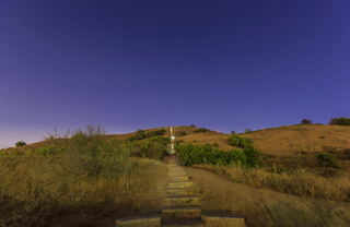 A trail of wooden steps in grassy hills