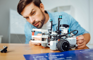 A person assembling a small robot