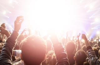 A crowd with hands in the air at a rave