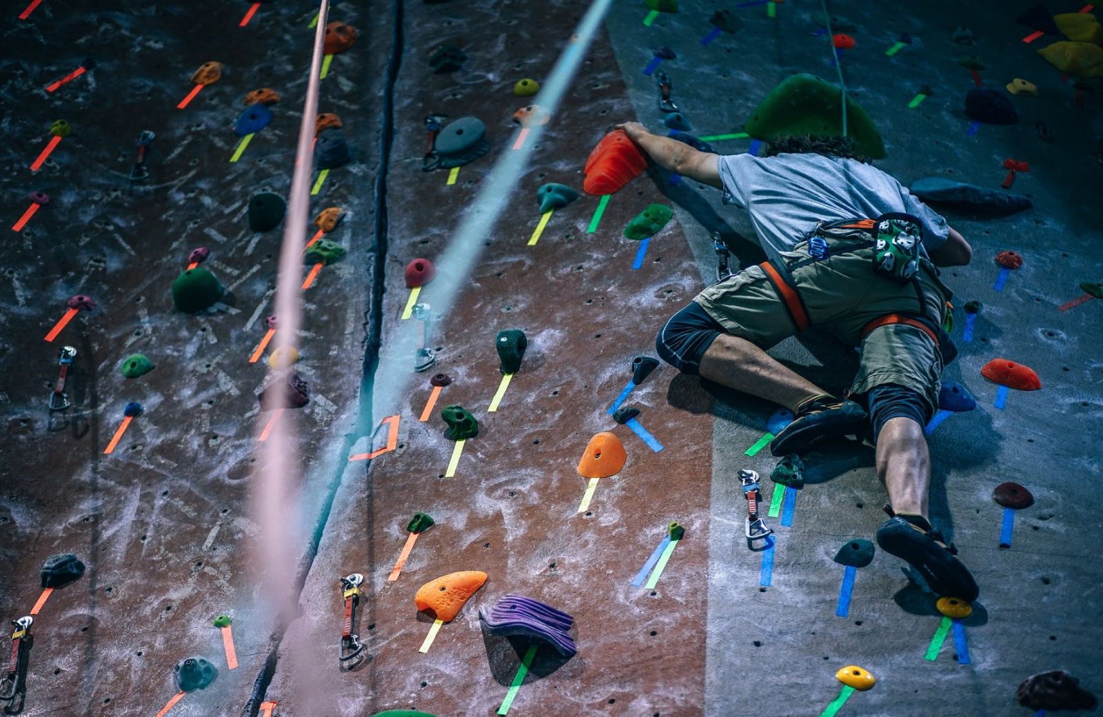 a guy high up on a Rock climbing wall in Norwalk - The Waypointe