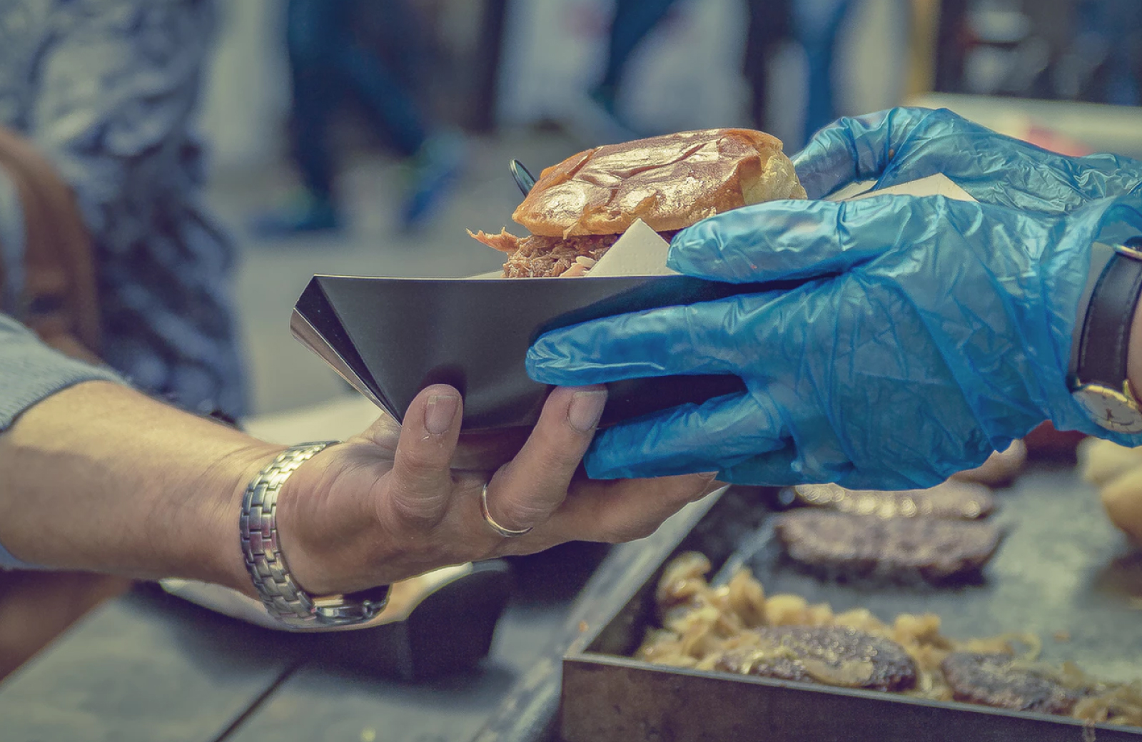 burger being handed to a customer in DTLA food festival