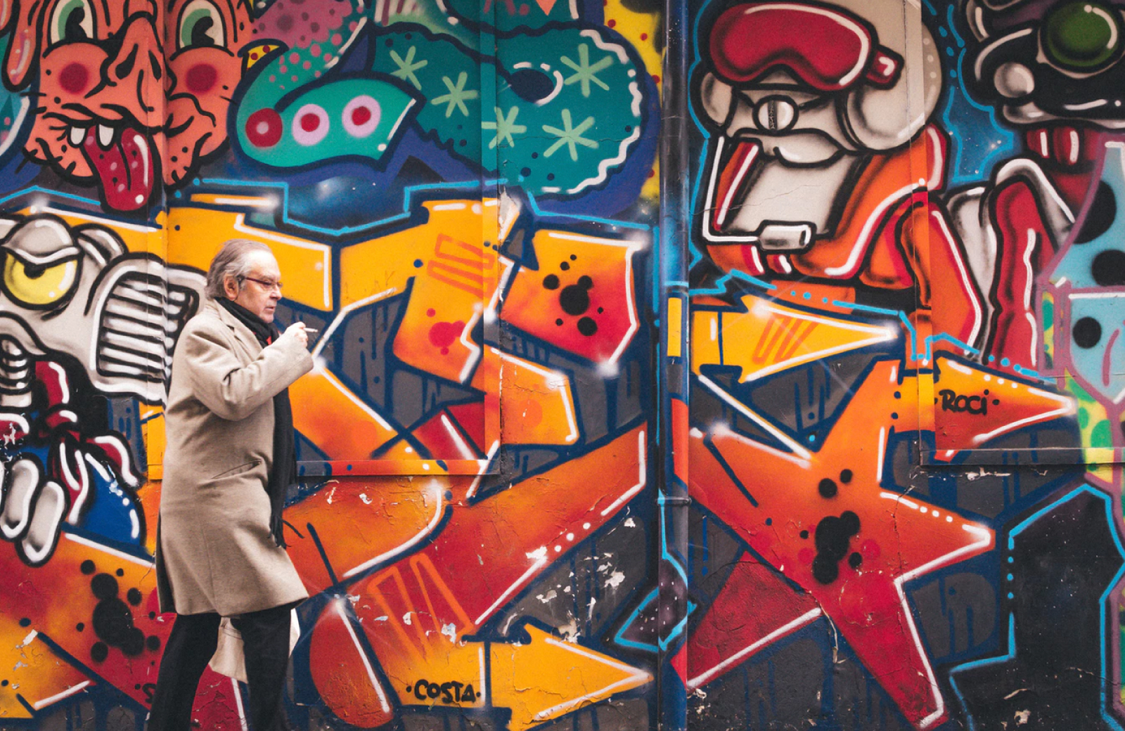 man passing through a wall with urban art in fidi ny