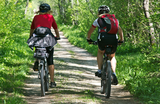 two bikers cycling through the forest norfolk waypointe