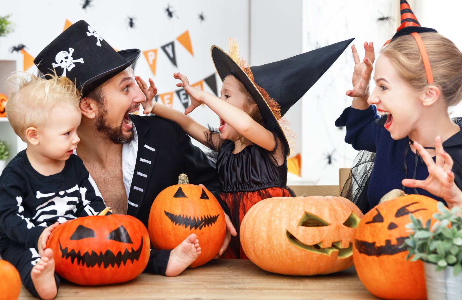 young family with two kids in halloween costumes surrounded by pumpkins waypointe norwalk