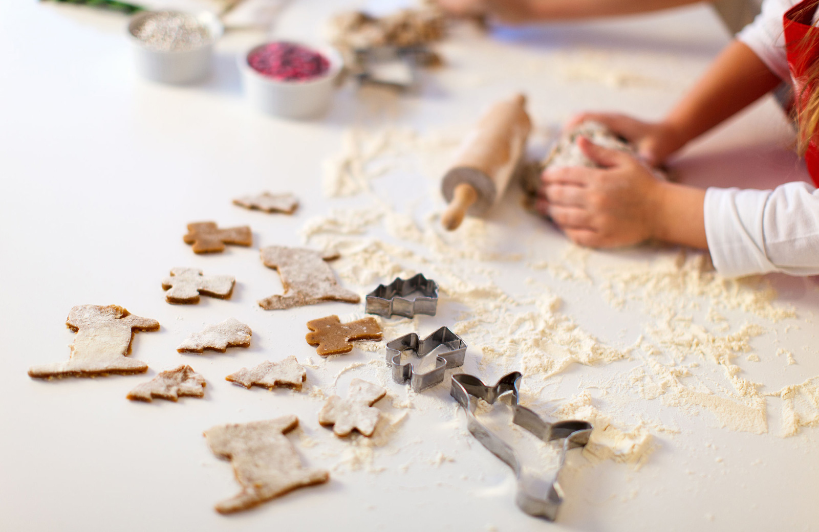 person's hands making holiday cookies with cookie cutters - hyde square bellevue apts