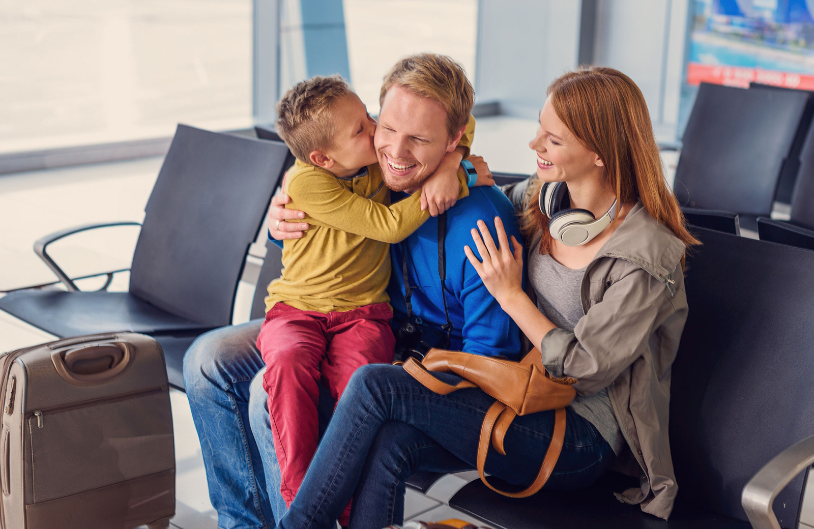 mom and dad with son on his lap in an airport - The Waypointe Apts