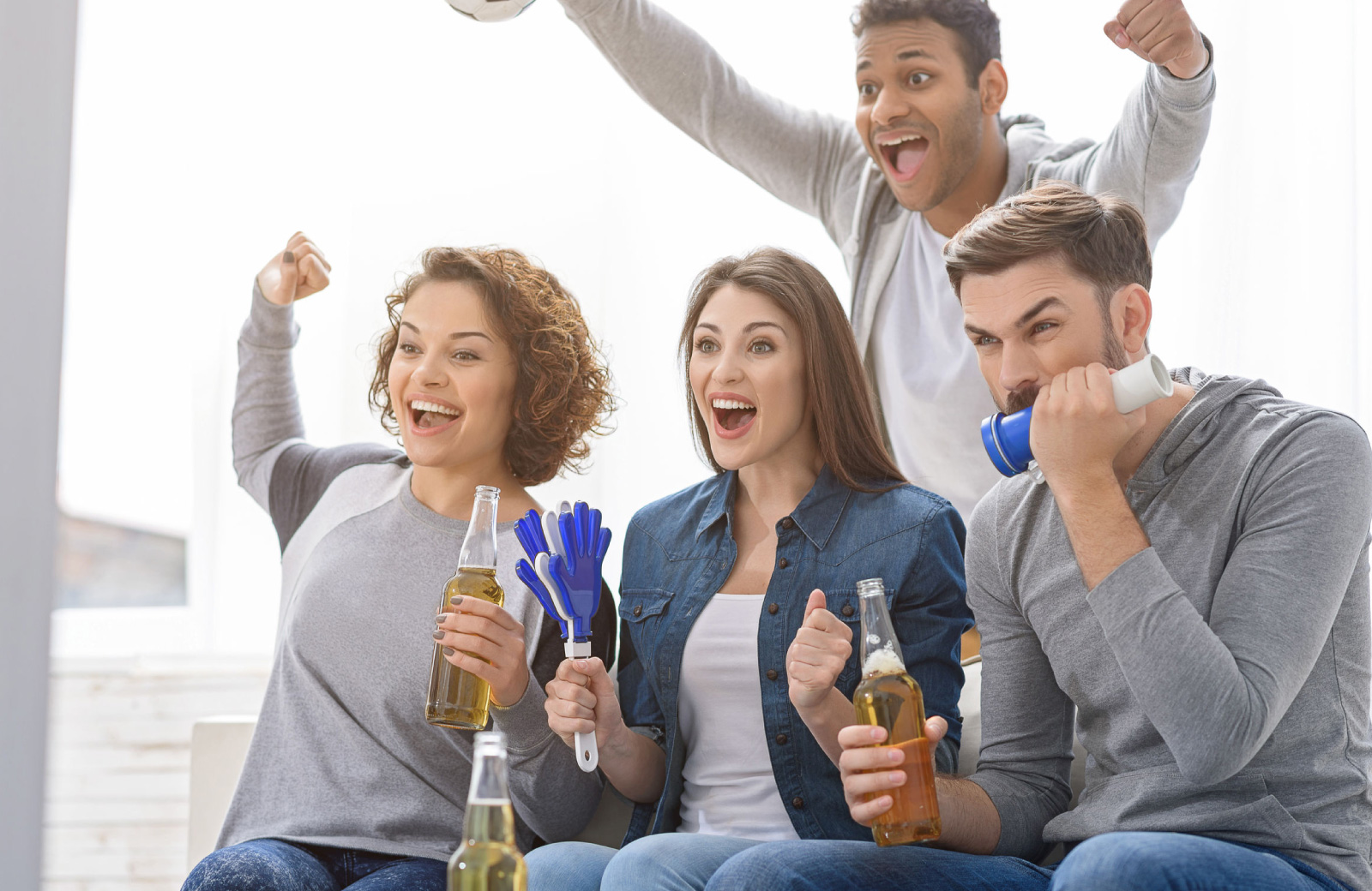 2 guys & 2 girls watching super bowl on tv excitedly - Hyde Square Apts
