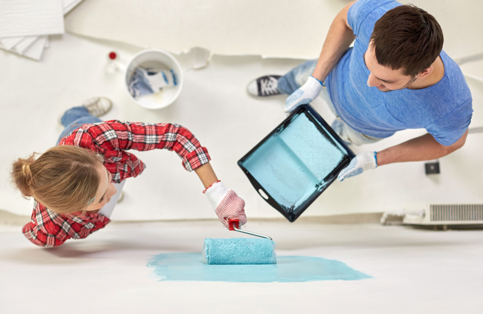 couple painting a wall inside house