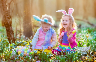 Two girls wearing bunny ears on an easter egg hunt