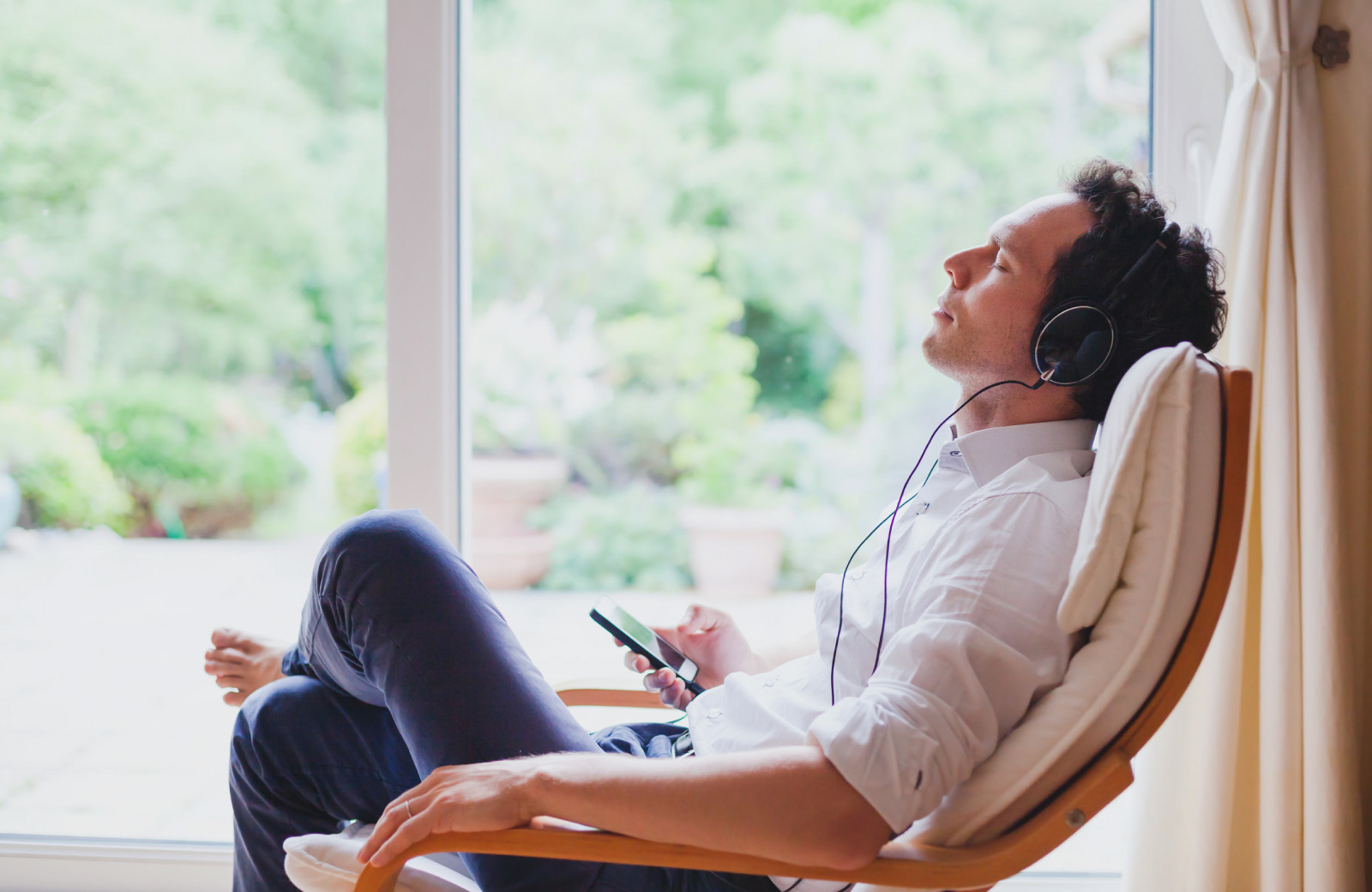 man with earphones relaxing on a chair