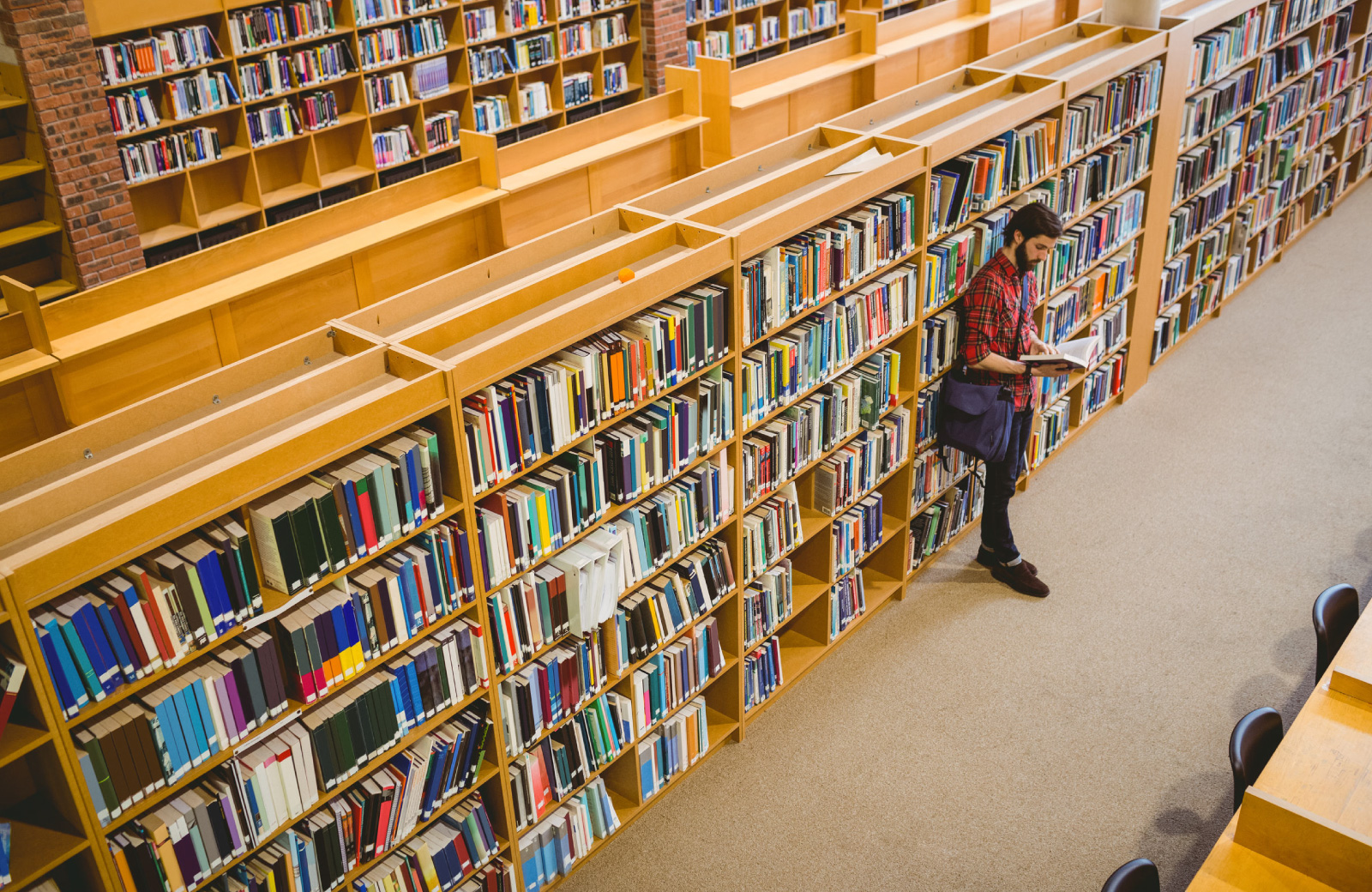 man checking out a book in the library