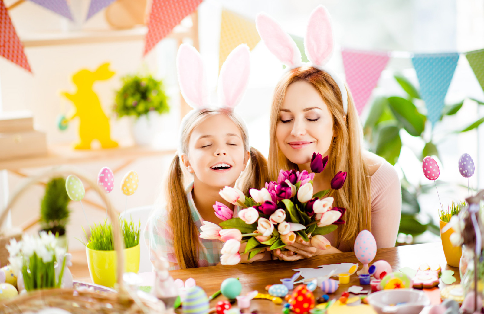 woman and girl smelling flowers