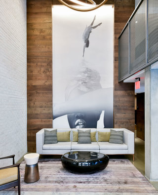 Fourth Street East lobby with modern lounge seating, sculptural lighting, and mail room access