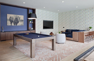 A game room with a pool table and lounge seating