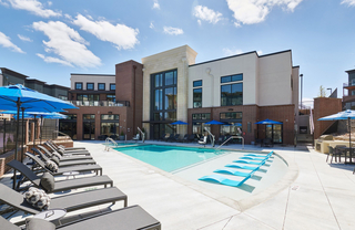 An outdoor pool deck with lots of lounge chairs