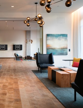 close up of two chairs and a coffee table in a large community room - hyde square amenities