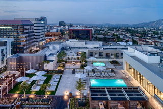 An aerial shot of the apartment building, with a rooftop terrace and pool