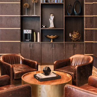 Four leather club chairs positioned around a coffee table in the resident lounge
