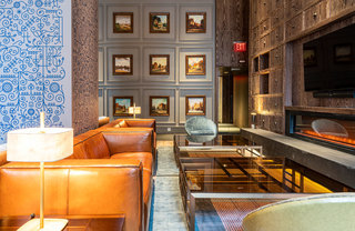 Cognac leather couches and seating near a linear gas fireplace in the resident lounge.