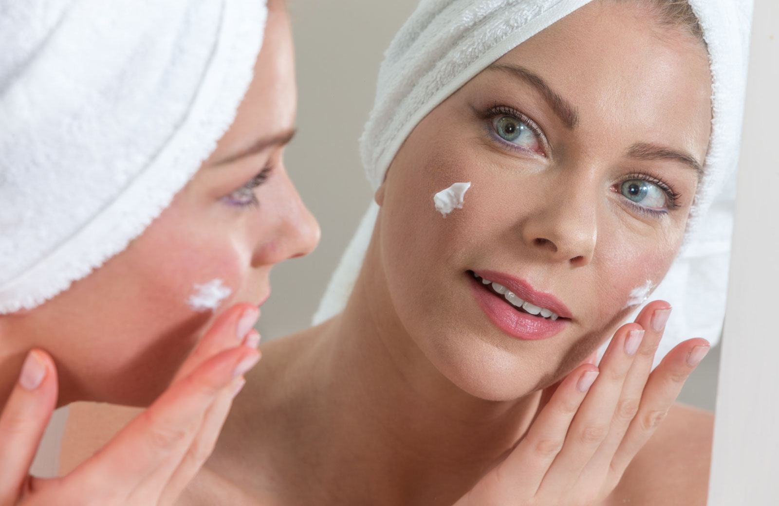 woman applying moisturizer on her face